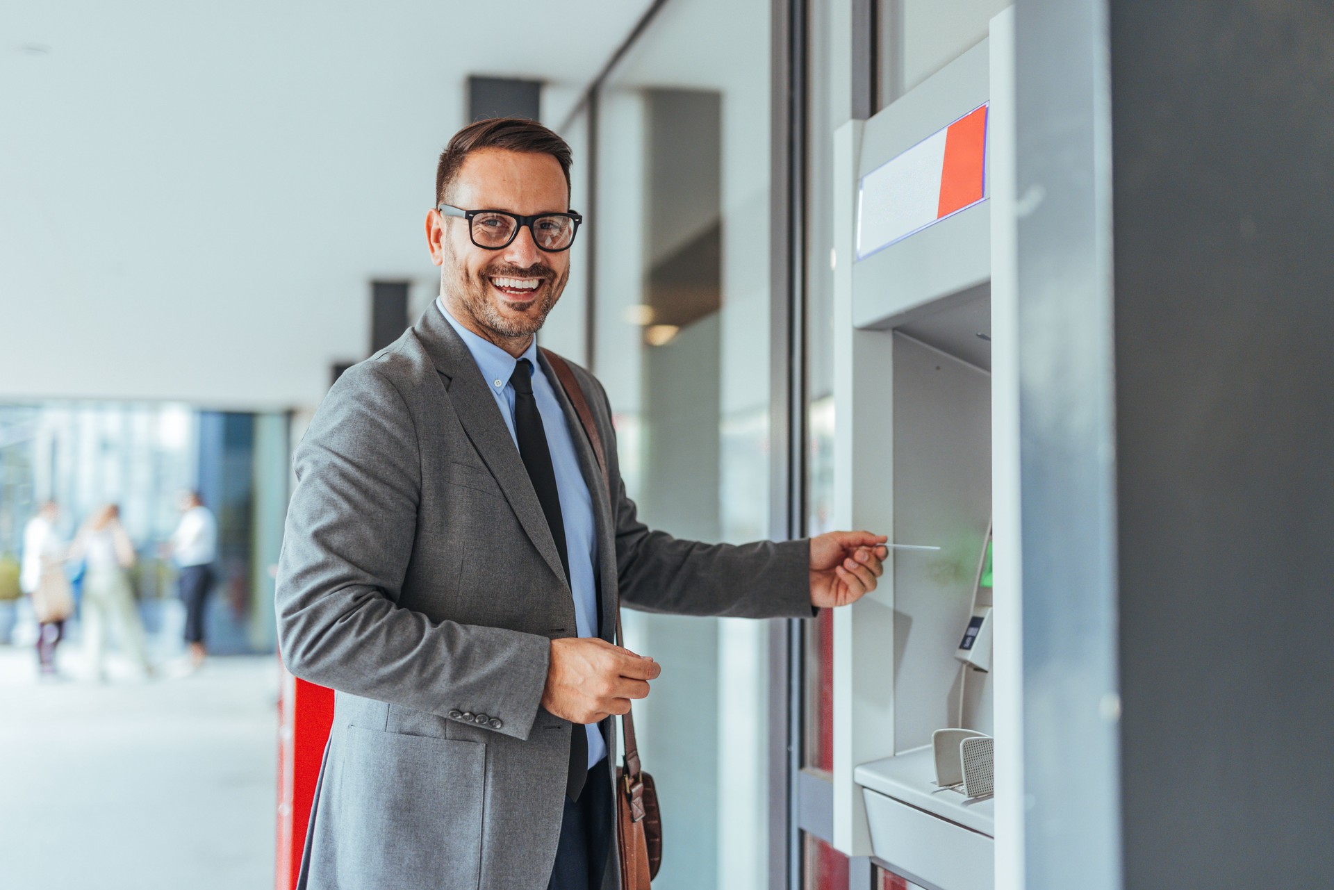 Businessman Smiling While Using ATM on a Bright Day